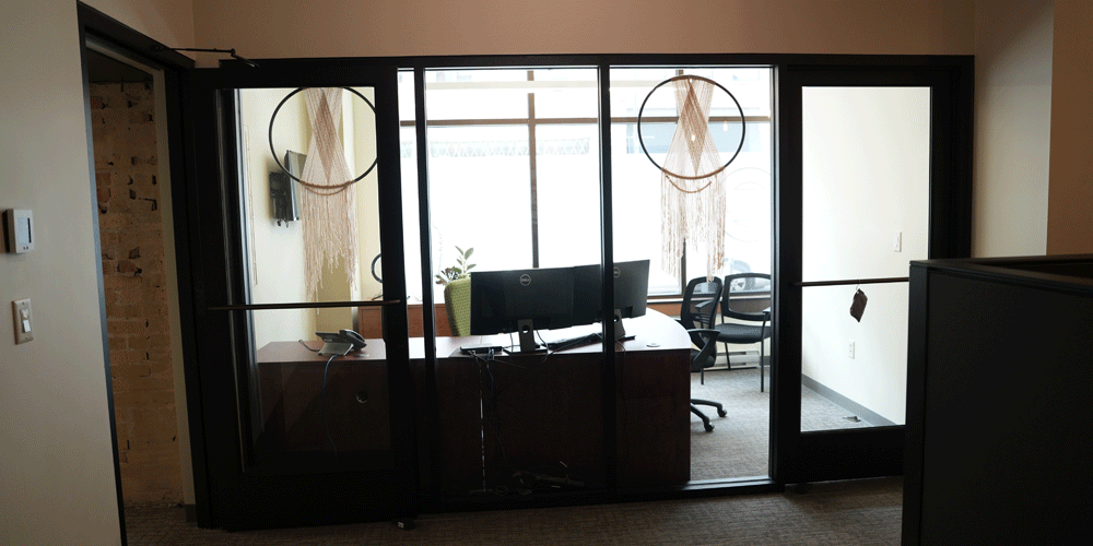 Private office in Duluth with window hangings in the windows and two computer screens.